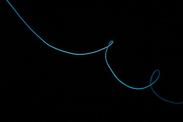 Minimalist abstract background with a single glowing blue neon line on a pure black backdrop. Simple futuristic design element. Blue laser abstract matrix background 