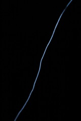 Minimalist abstract background with a single glowing blue neon line on a pure black backdrop. Simple futuristic design element. Blue laser abstract matrix background 