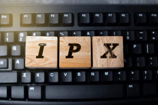 Wooden blocks displaying the letters &ldquo;IPX&rdquo; placed on a computer keyboard, representing technology, digital communication, information concepts, and modern workspace elements.