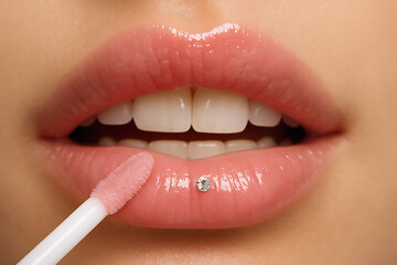 Naklejka premium woman applying lip gloss