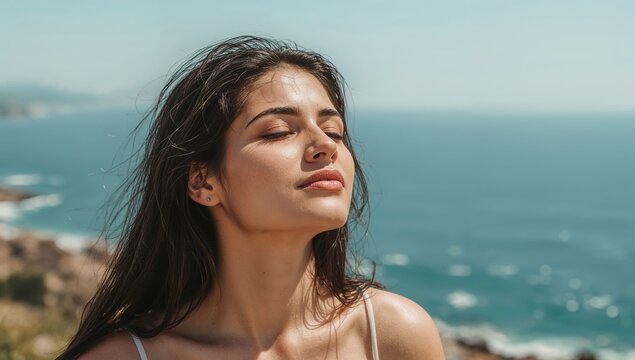 Woman with eyes closed enjoying ocean sunshine
