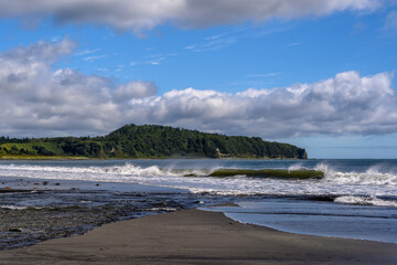 Waves crashing on the shore along the beautiful Russian coastline on a sunny day