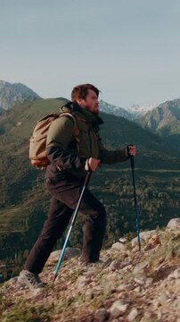man hiking mountain at sunrise with trekking poles slow motion journey freedom lifestyle