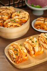 Homemade Steamed Pork Buns with Scallions and Spicy Filling on Wooden Serving Plates