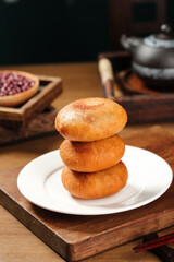 Handmade Deep-Fried Donuts Stacked on Plate with Traditional Tea Setting and Red Bean Paste