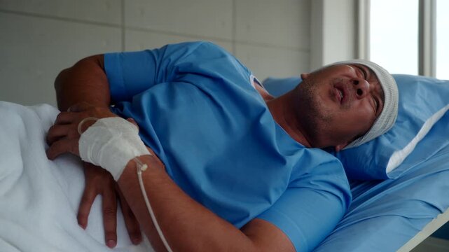 Elderly Asian cancer patient man lying on hospital bed suffers from severe stomach pain and diarrhea. Health insurance for treatment support.
