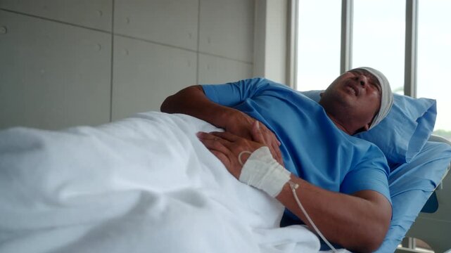 Elderly Asian cancer patient man lying on hospital bed suffers from severe stomach pain and diarrhea. Health insurance for treatment support.
