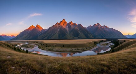 Majestic mountain range landscape with river flowing through golden fields at sunset