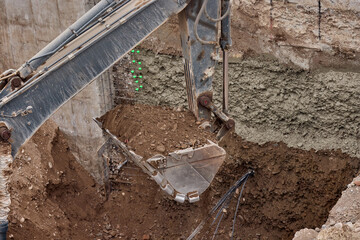 Excavator bucket digging into soil during construction work, showing power, precision, and heavy...