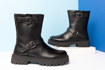 Black leather women boots on color background