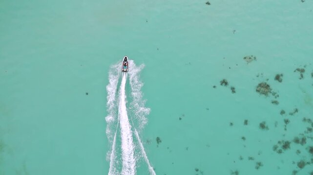 Aerial View of Tourists Enjoying Jet Ski Ride in Turquoise Sea Water on Karimunjawa Island Beach