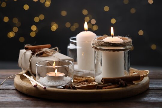 Christmas lanterns, matches and spices on wooden table against dark background with blurred lights, closeup. Bokeh effect - Powered by Adobe