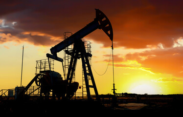 Pumpjack in oil well of oil field on sunset in Industrial crude area. Crude pump jack working on oil field. Pumpjack, Oil drill rig, drilling derrick in oilfield. Natural gas, Crude petroleum industry