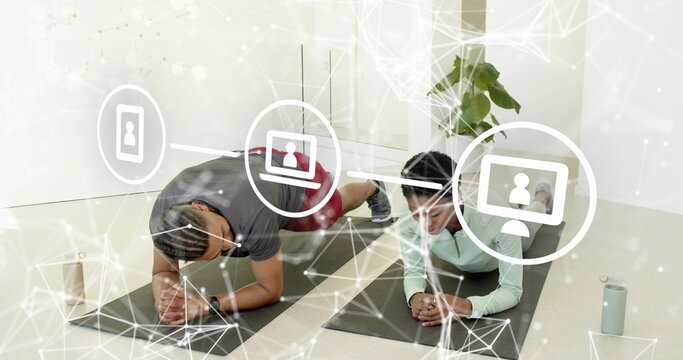 Performing two adults in gray and mint holding forearm planks in studio with mats, digital overlays