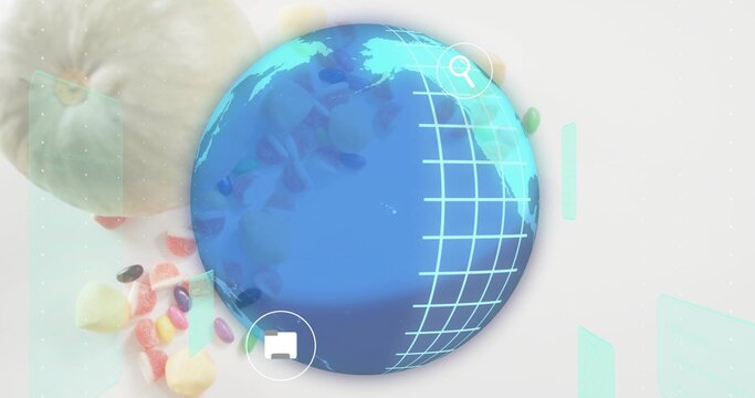Displaying globe with cyan grid on tabletop, search and folder icons, candies, mint-green sleeve