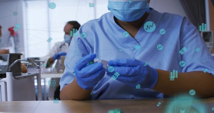 Preparing masked, gloved nurse in light blue scrubs drawing vial with syringe at clinic, data icons