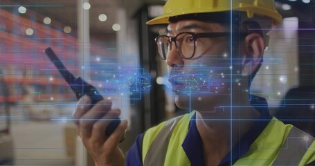Talking warehouse worker holding radio in warehouse, with hard hat and vest, AR, copy space