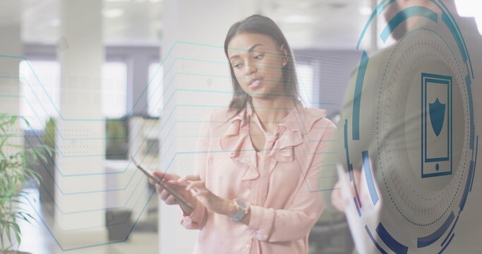 Using woman in pink ruffled blouse tapping tablet at office, wristwatch, HUD showing shield icon