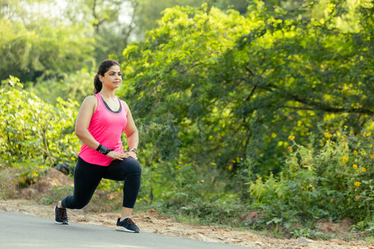 Fit Indian Woman Doing a Lunge Exercise for Lower Body Strength Outdoors