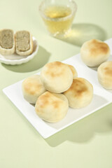 Traditional Mung Bean Pastry Cakes with Tea - Classic Asian Dessert Served on White Plates