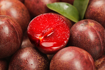 Fresh Red Plums Cut in Half Showing Juicy Flesh - Healthy Organic Stone Fruit