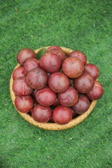 Fresh Red Plums in Wicker Basket on Grass - Organic Stone Fruit Harvest