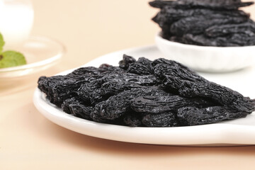 Xinjiang Black Raisins on White Plates - Premium Dried Fruit Beauty
