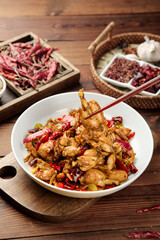 Spicy Stir-Fried Bullfrog with Chili Peppers Traditional Chinese Cuisine in White Bowl on Wooden Background