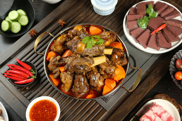 Asian braised lamb stew with vegetables in copper pot traditional dinner spread