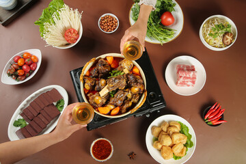 Traditional Hot Pot with Braised Lamb and Fresh Vegetables on Wooden Table