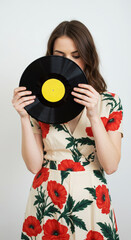 Obraz premium Woman hides face with record in studio portrait