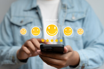 Satisfaction review, User giving five-star rating with happy emoji icon on smartphone screen, representing excellent customer feedback, digital reputation, and mobile user experience concept.