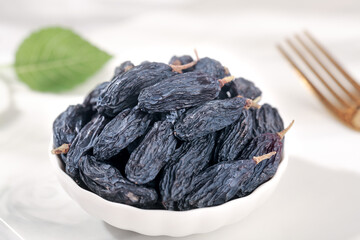 Turpan Black Dried Grapes from Xinjiang China in White Bowl with Natural Styling