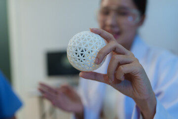 Researchers are working with a 3D printer to print clear, white plastic models using cutting-edge, focused technology in the lab.