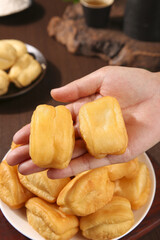 Traditional Crispy Golden Fritters - Delicious Breakfast Pastry Hand Held Over Plate