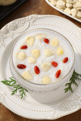 Traditional almond porridge with goji berries and nuts in glass bowl, nutritious breakfast meal
