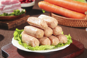 Raw Sausages on Plate Ready for Barbecue Cooking with Fresh Ingredients on Wooden Kitchen Table