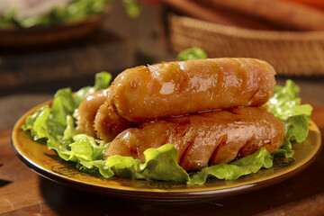 Grilled Sausages on Lettuce Leaves - Traditional Barbecue Food on Rustic Wooden Table