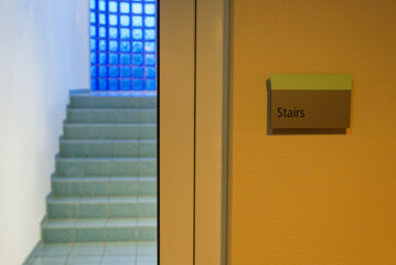 Wall sign for stairs with steps visible in soft background