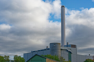 Flensburg power plant with tall chimney under dramatic cloudy sky in northern Germany