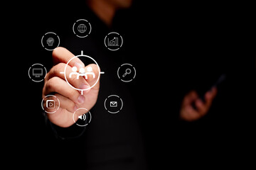 A person interacts with digital icons, symbolizing technology and communication in a dark environment.