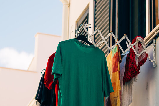 Colorful clothes drying on balcony rack