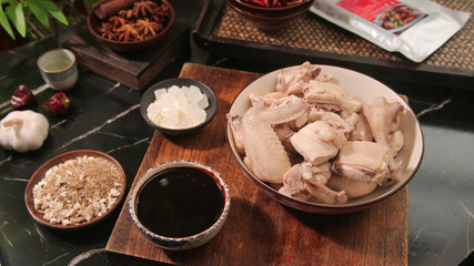 Raw chicken nuggets with Asian spices and soy sauce for braised cooking preparation on wooden board