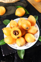 Fresh Loquat Fruits on White Plate with Green Leaves - Healthy Asian Stone Fruit Display