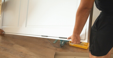 Caucasian carpenter installing door in a apartment.