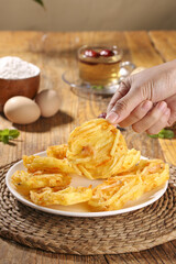 Traditional Chinese Fried Potato Spirals - Golden Crispy Snack Food on Rustic Wooden Table
