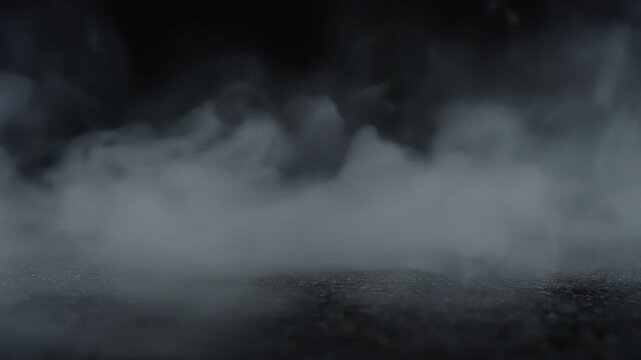 Pale mist flowing and meandering over a shadowy, intricately patterned backdrop. Smoky haze gliding along the surface with a deep, inky background