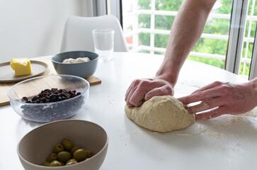Manos amasando masa para la elaboración de pan artesanal. Panadería casera.