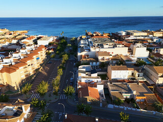 Beautiful aerial view of Torre de la Horadada, Spain, with white Mediterranean houses, calm streets, and the blue  sea in golden evening light. Costa Blanca