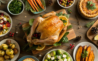 Overhead shot of a thanksgiving dinner table with a roasted turkey, various side dishes, and autumn decorations, a festive and abundant holiday feast christmas